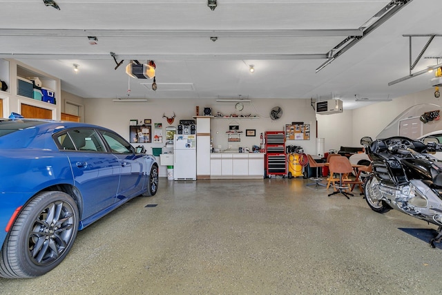 garage featuring white fridge and a garage door opener