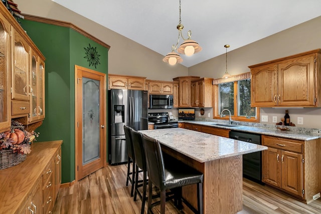 kitchen with sink, a kitchen island, black appliances, and light hardwood / wood-style floors