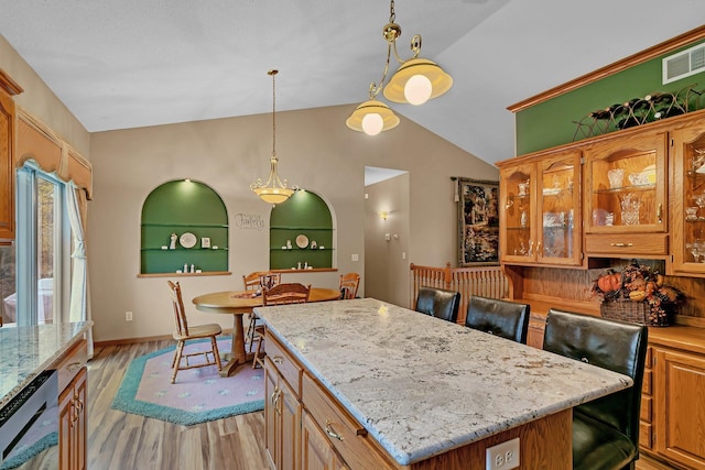 kitchen featuring vaulted ceiling, decorative light fixtures, light hardwood / wood-style floors, a kitchen island, and built in shelves