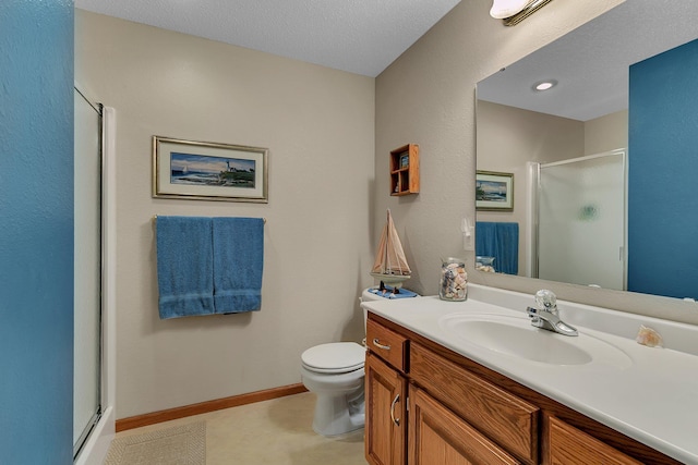 bathroom with toilet, a shower with door, vanity, and a textured ceiling