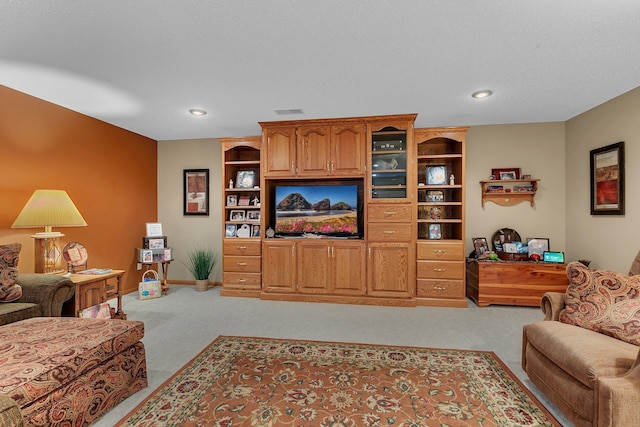 living room featuring built in shelves, a textured ceiling, and light carpet