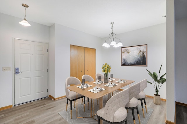 dining space featuring light hardwood / wood-style floors and an inviting chandelier