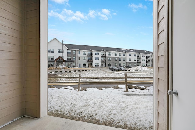 view of snow covered back of property