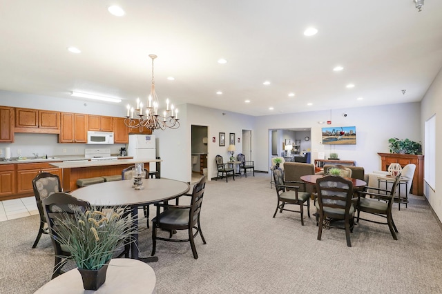 dining space featuring light carpet, sink, and an inviting chandelier