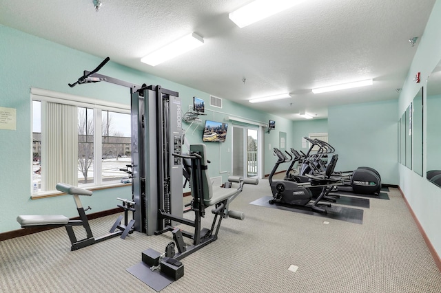 gym featuring carpet and a textured ceiling