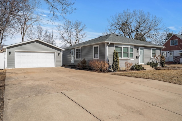 single story home featuring an outbuilding, driveway, a garage, and roof with shingles