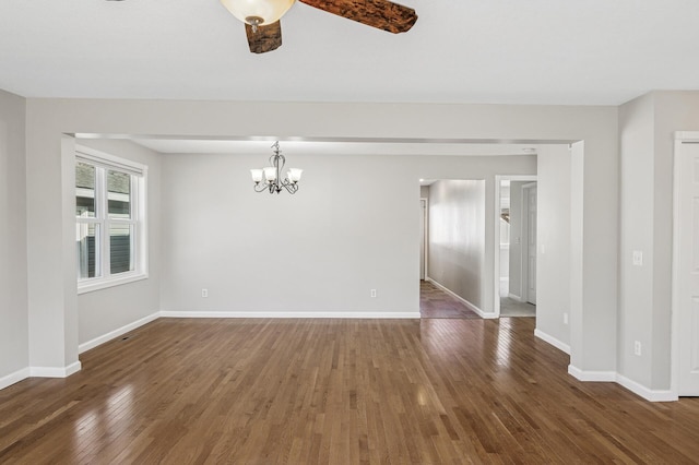 unfurnished room with an inviting chandelier, hardwood / wood-style flooring, and baseboards