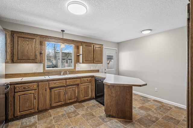 kitchen with baseboards, light countertops, black dishwasher, a peninsula, and stone finish floor