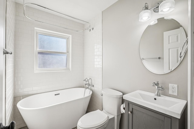 bathroom with a soaking tub, vanity, and toilet