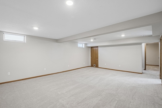 below grade area featuring recessed lighting, baseboards, light carpet, and visible vents