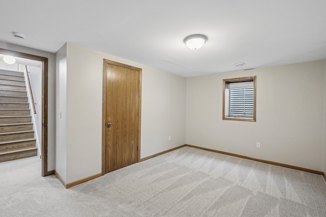 interior space with baseboards, light carpet, and stairs