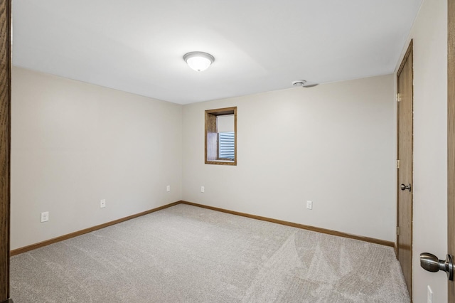 spare room with baseboards and carpet floors