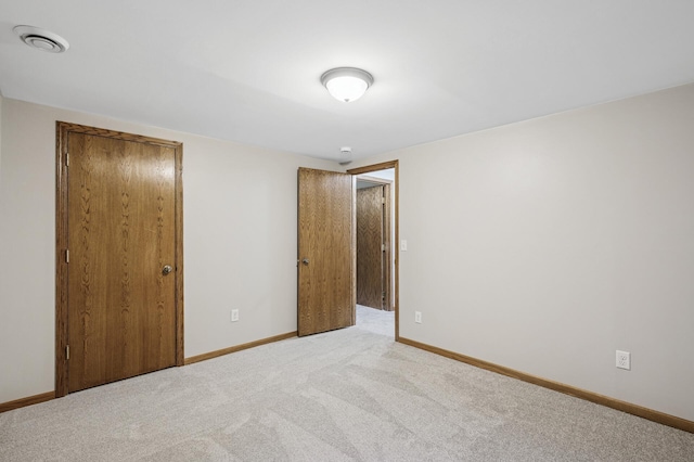 unfurnished bedroom with visible vents, light carpet, baseboards, and a closet