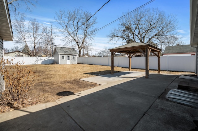 view of patio with a gazebo, a fenced backyard, a carport, and an outdoor structure