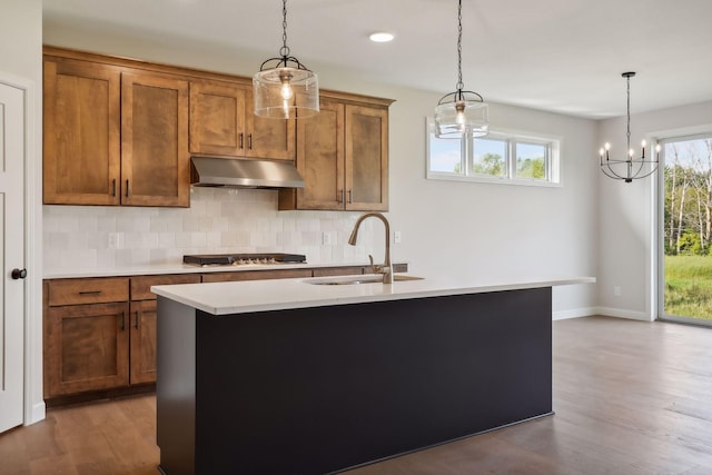 kitchen featuring sink, pendant lighting, stainless steel gas cooktop, and a kitchen island with sink