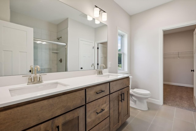 bathroom with tile patterned flooring, toilet, a shower with door, and vanity