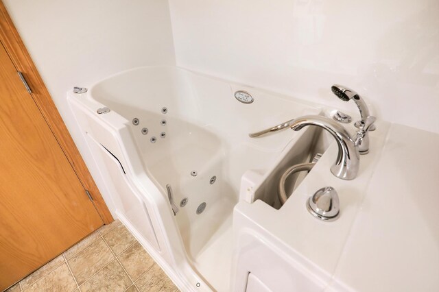 bathroom with tile patterned floors and a tub