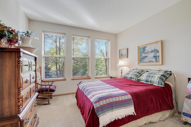 bedroom featuring a textured ceiling and light carpet