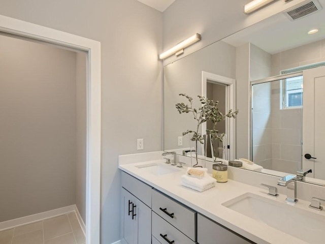 bathroom featuring tile patterned flooring, an enclosed shower, and vanity