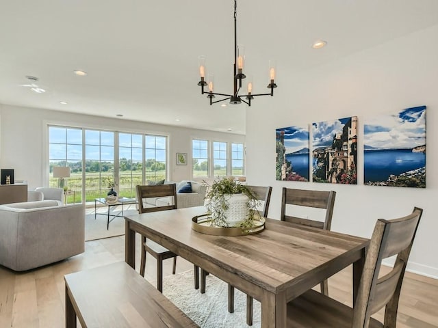 dining area featuring light wood-type flooring and a notable chandelier