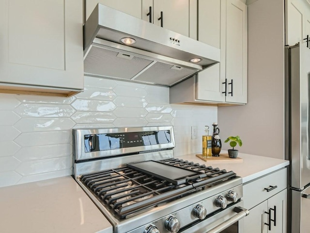 kitchen with stainless steel appliances, white cabinets, and tasteful backsplash