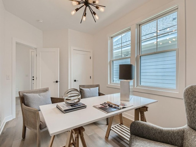 office space featuring a healthy amount of sunlight, light hardwood / wood-style flooring, and a chandelier