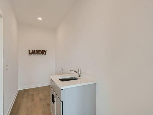 laundry room featuring light wood-type flooring and sink