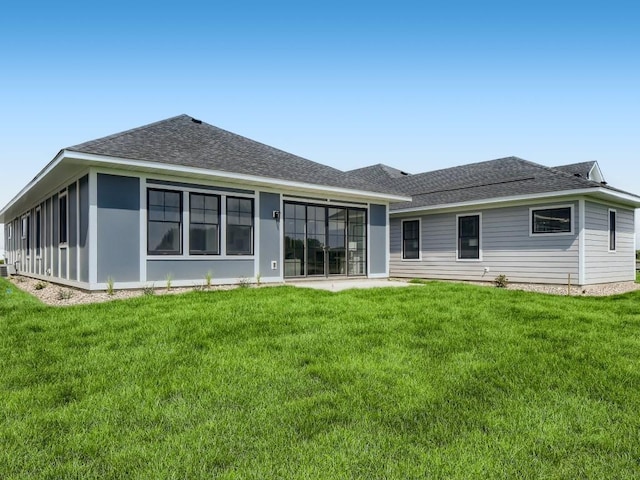 rear view of house with a yard and a sunroom