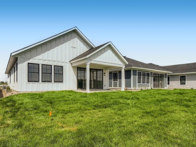 back of house with a yard and a sunroom