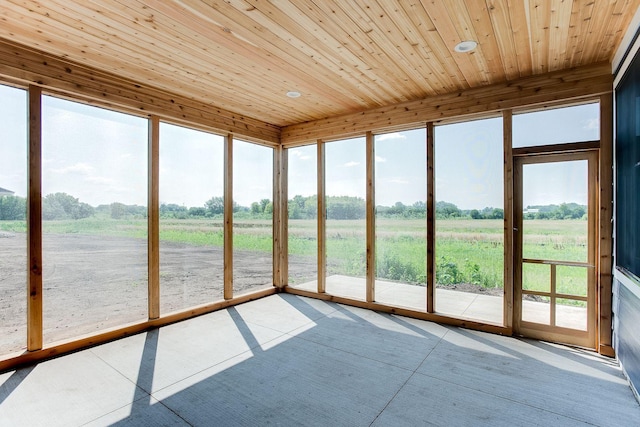 unfurnished sunroom featuring wood ceiling and a rural view