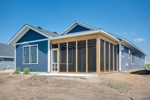 back of property with a sunroom