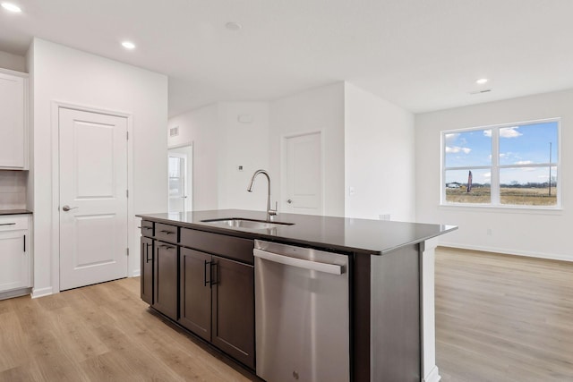 kitchen featuring stainless steel dishwasher, light hardwood / wood-style flooring, an island with sink, white cabinetry, and sink