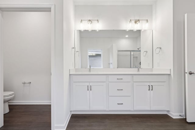 bathroom featuring walk in shower, toilet, vanity, and hardwood / wood-style flooring