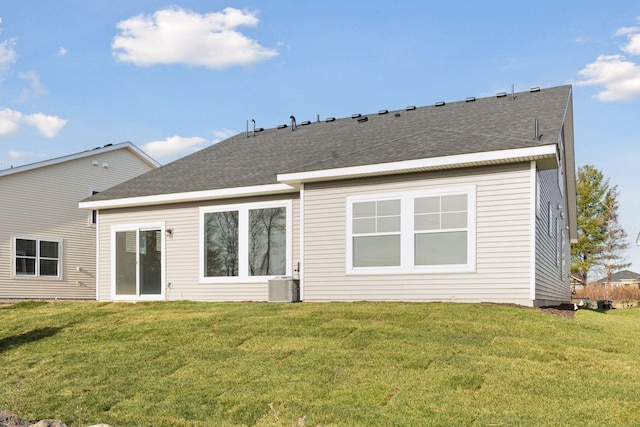 rear view of property with a yard and central AC