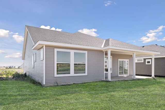 rear view of property featuring a yard and a patio area