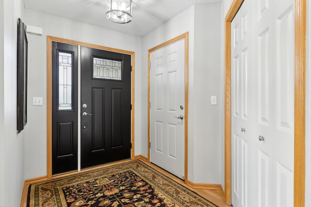 foyer featuring a textured ceiling and a notable chandelier