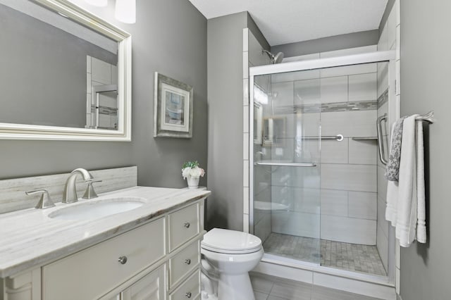 bathroom featuring a textured ceiling, an enclosed shower, tile patterned flooring, vanity, and toilet