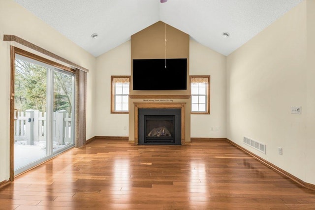 unfurnished living room featuring lofted ceiling and hardwood / wood-style flooring