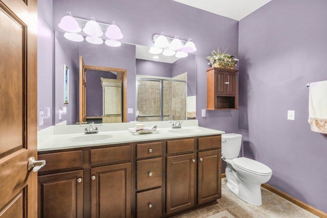 bathroom featuring a shower with shower door, vanity, tile patterned floors, and toilet