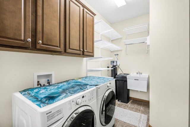 laundry area with light tile patterned floors, cabinets, washer and clothes dryer, and sink