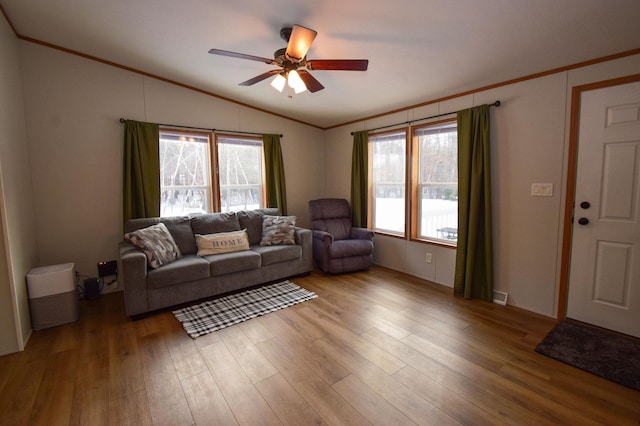 living room featuring light hardwood / wood-style floors, ceiling fan, vaulted ceiling, and ornamental molding