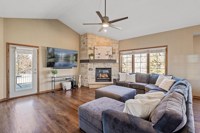 living room with lofted ceiling, dark wood finished floors, a stone fireplace, and baseboards