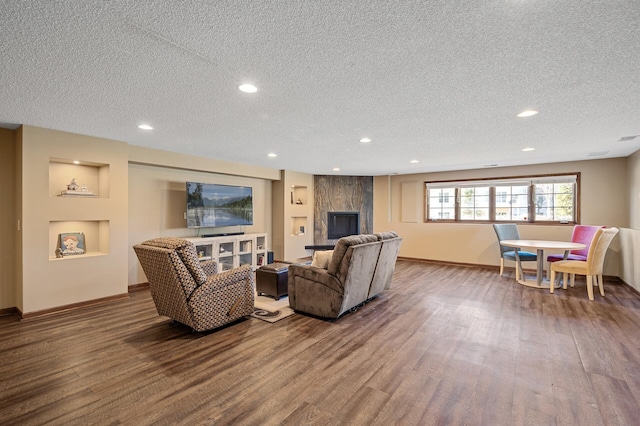 living area featuring a textured ceiling, baseboards, wood finished floors, and recessed lighting