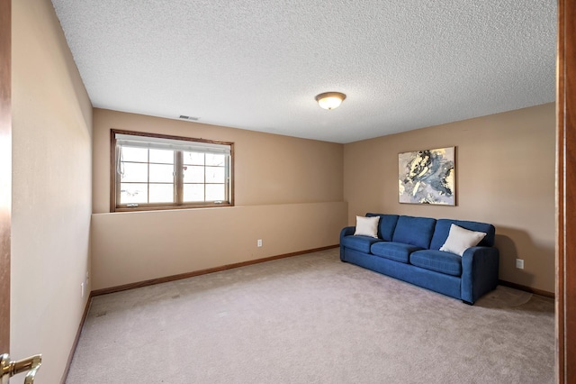 living area featuring carpet floors, baseboards, visible vents, and a textured ceiling