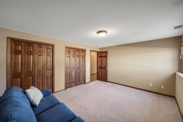 living room featuring baseboards, visible vents, and light colored carpet