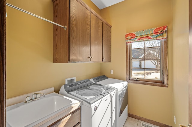 laundry room with light tile patterned floors, a sink, baseboards, cabinet space, and washing machine and clothes dryer