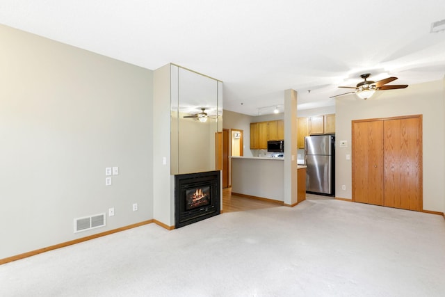 unfurnished living room with ceiling fan and light carpet