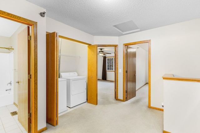 laundry area featuring independent washer and dryer, a textured ceiling, and light colored carpet