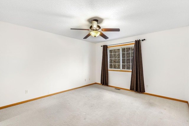 carpeted empty room featuring a textured ceiling and ceiling fan