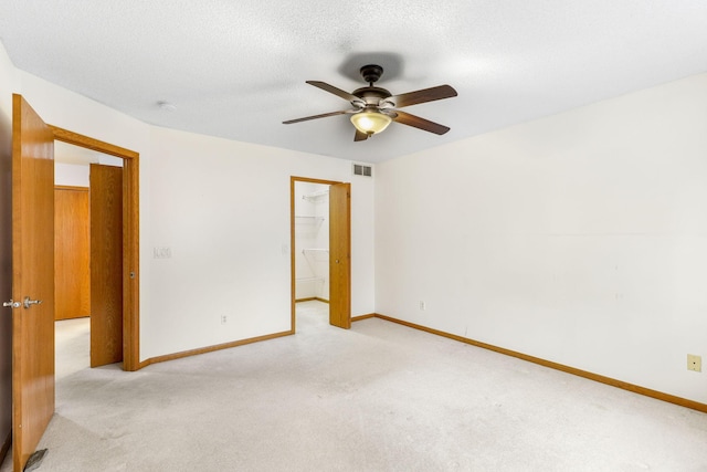 spare room featuring ceiling fan and light colored carpet